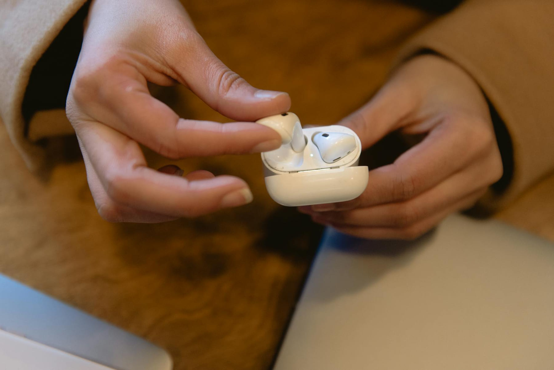 Person holding wireless earbuds, showcasing modern tech and design. on The Tech Shelf