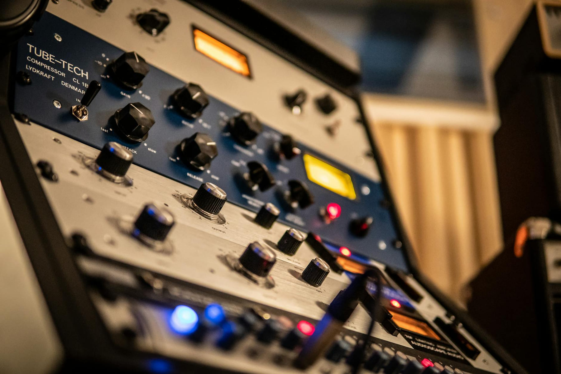 Detailed view of knobs on a Tube-Tech audio compressor in a studio setting. on The Tech Shelf