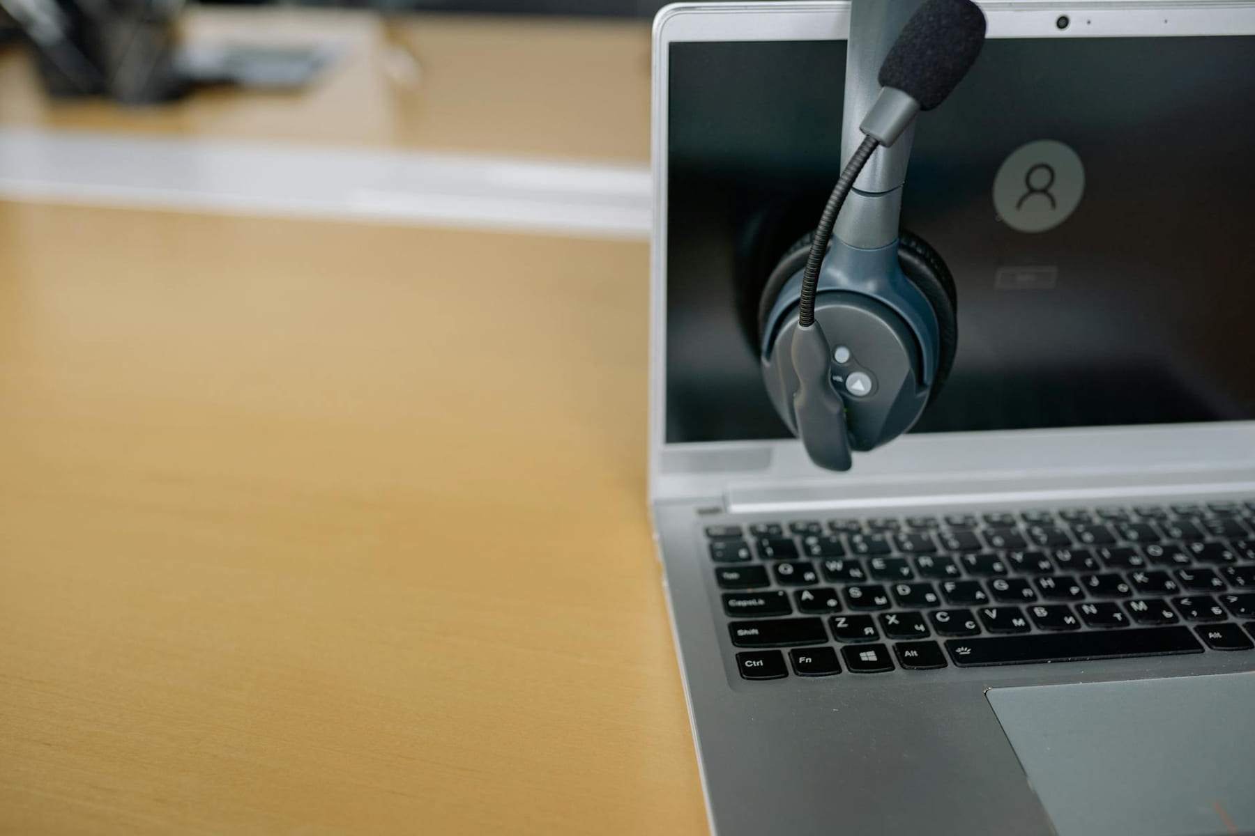 Close-up of wireless headset on laptop screen, ideal for communication tech visuals. on The Tech Shelf