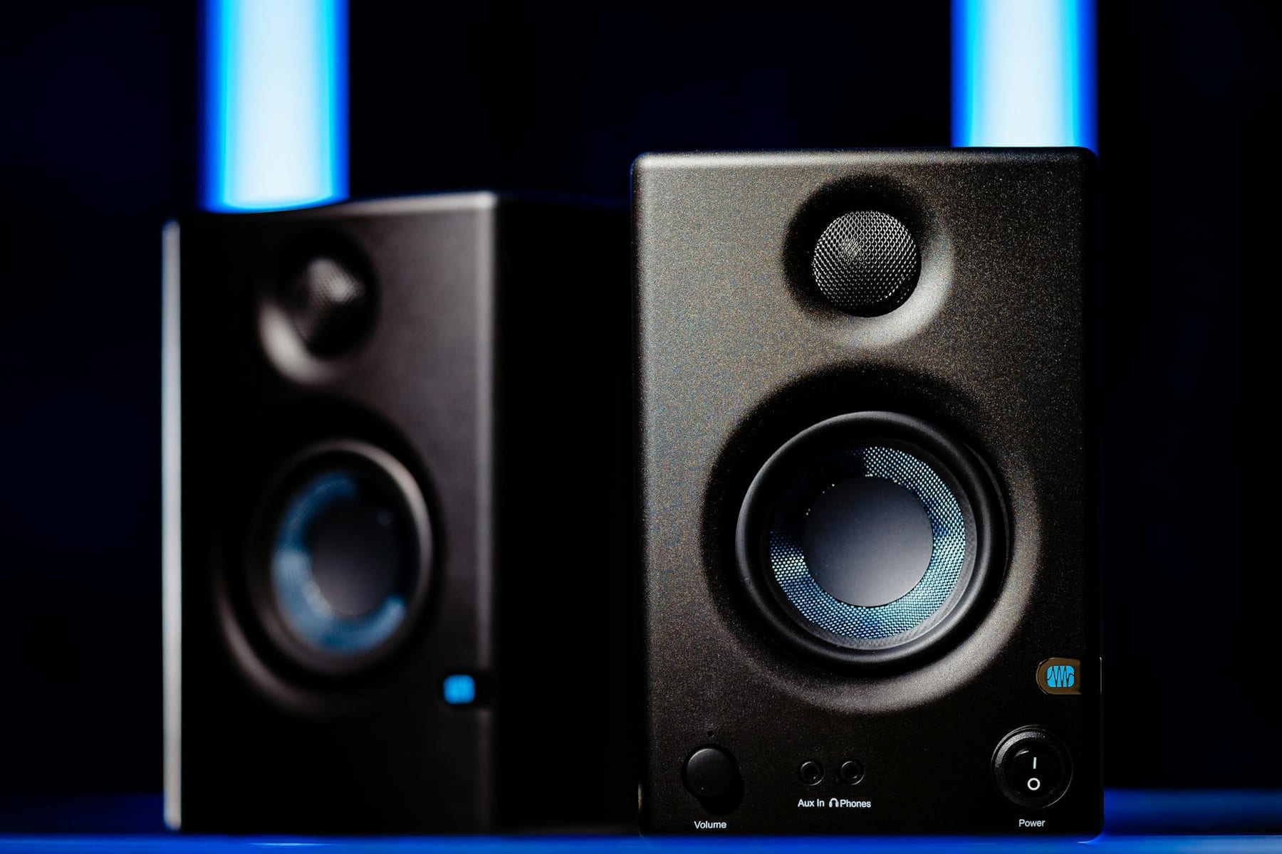 Close-up of modern black loudspeakers with blue accents in a studio setting. on The Tech Shelf