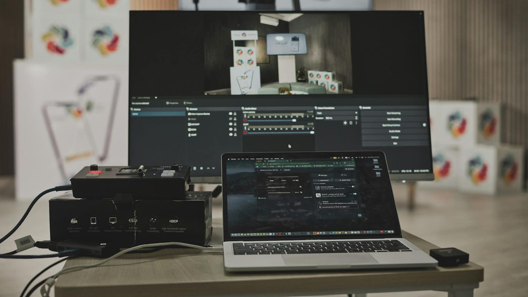 Multimedia setup featuring a laptop and a large monitor in a tech-savvy workspace. on The Tech Shelf