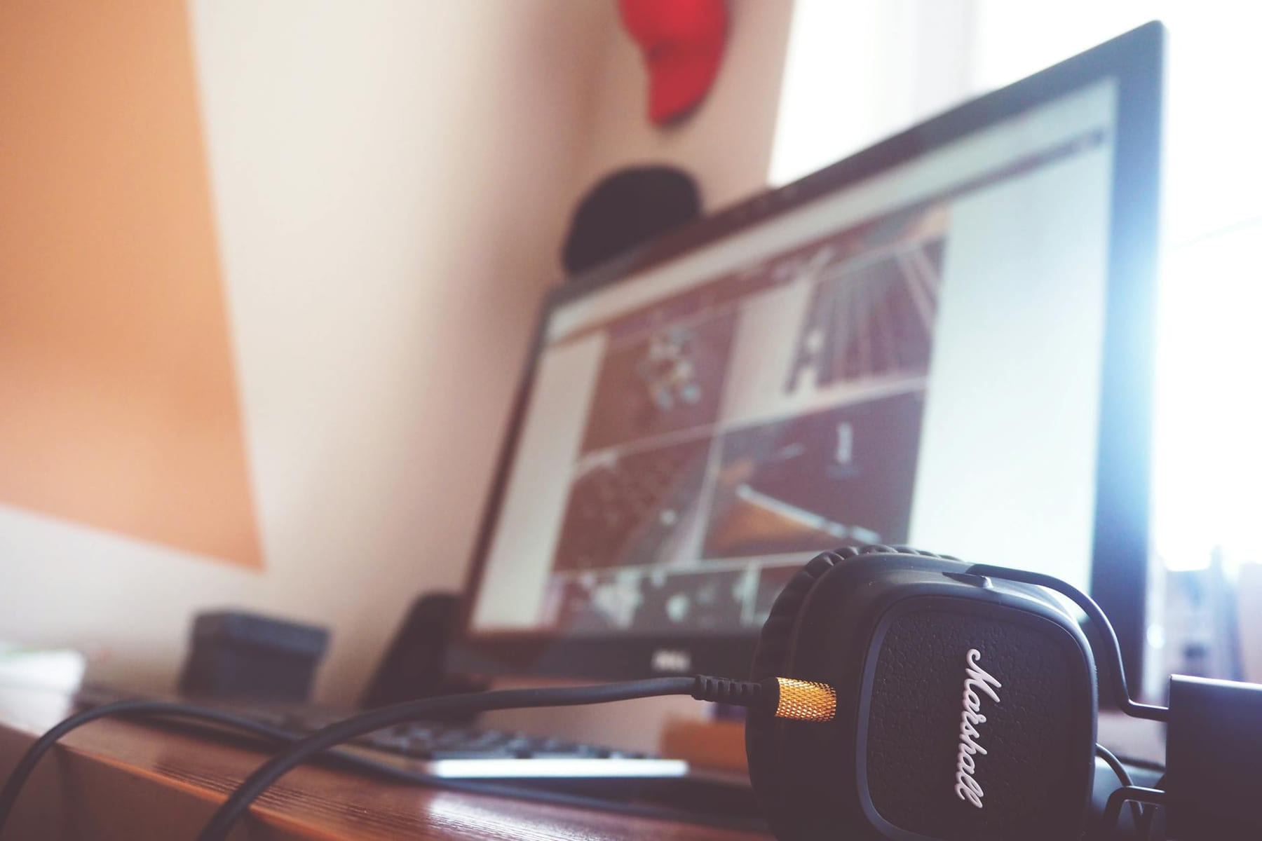 A contemporary desk setup featuring headphones and a computer screen displaying digital content. on The Tech Shelf