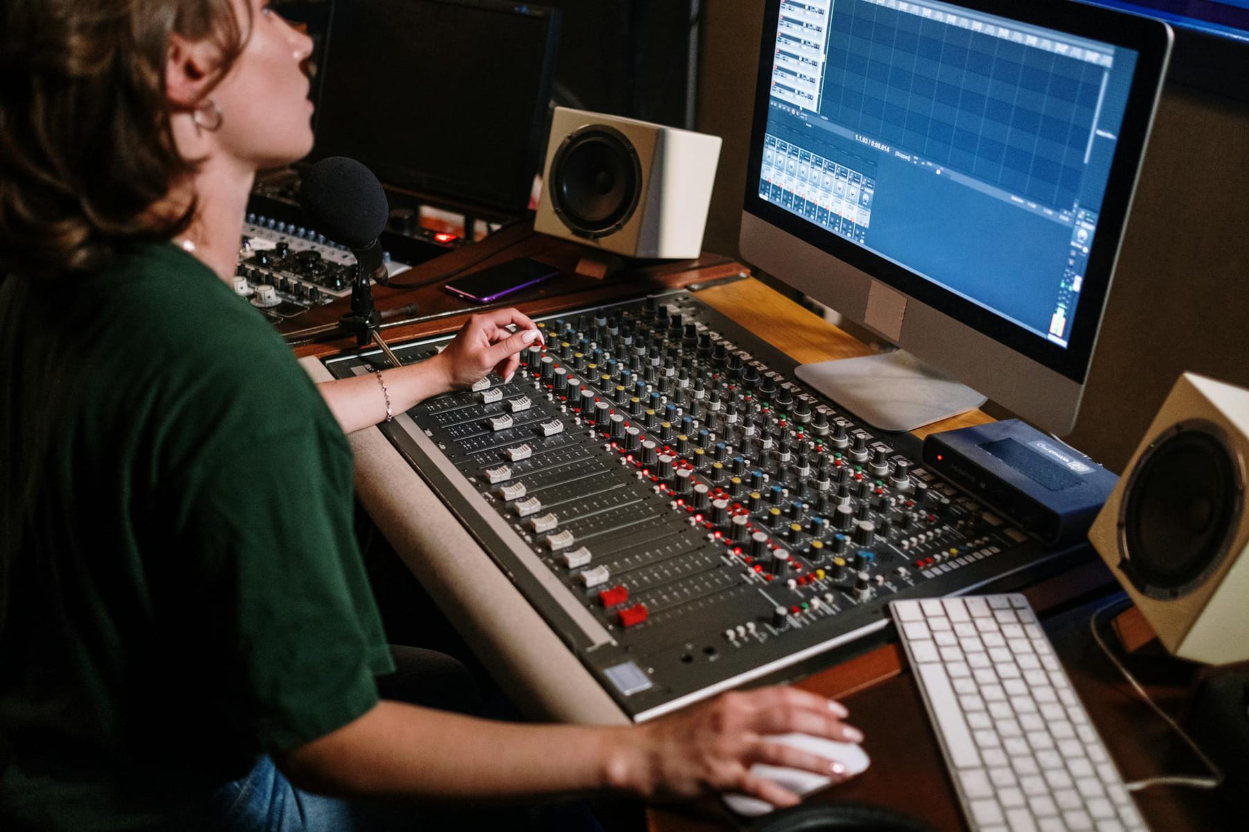 A sound engineer adjusting audio levels at a mixer desk in a recording studio with high-tech equipment. on The Tech Shelf
