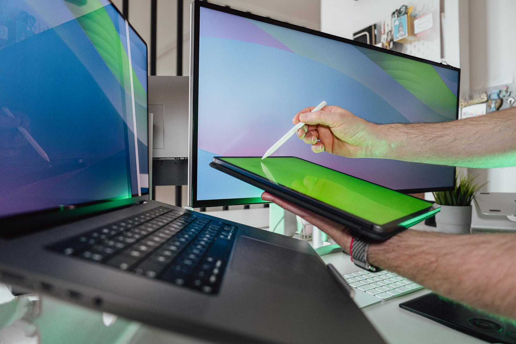 A person using a stylus on a tablet in a tech-savvy workspace with dual monitors on The Tech Shelf
