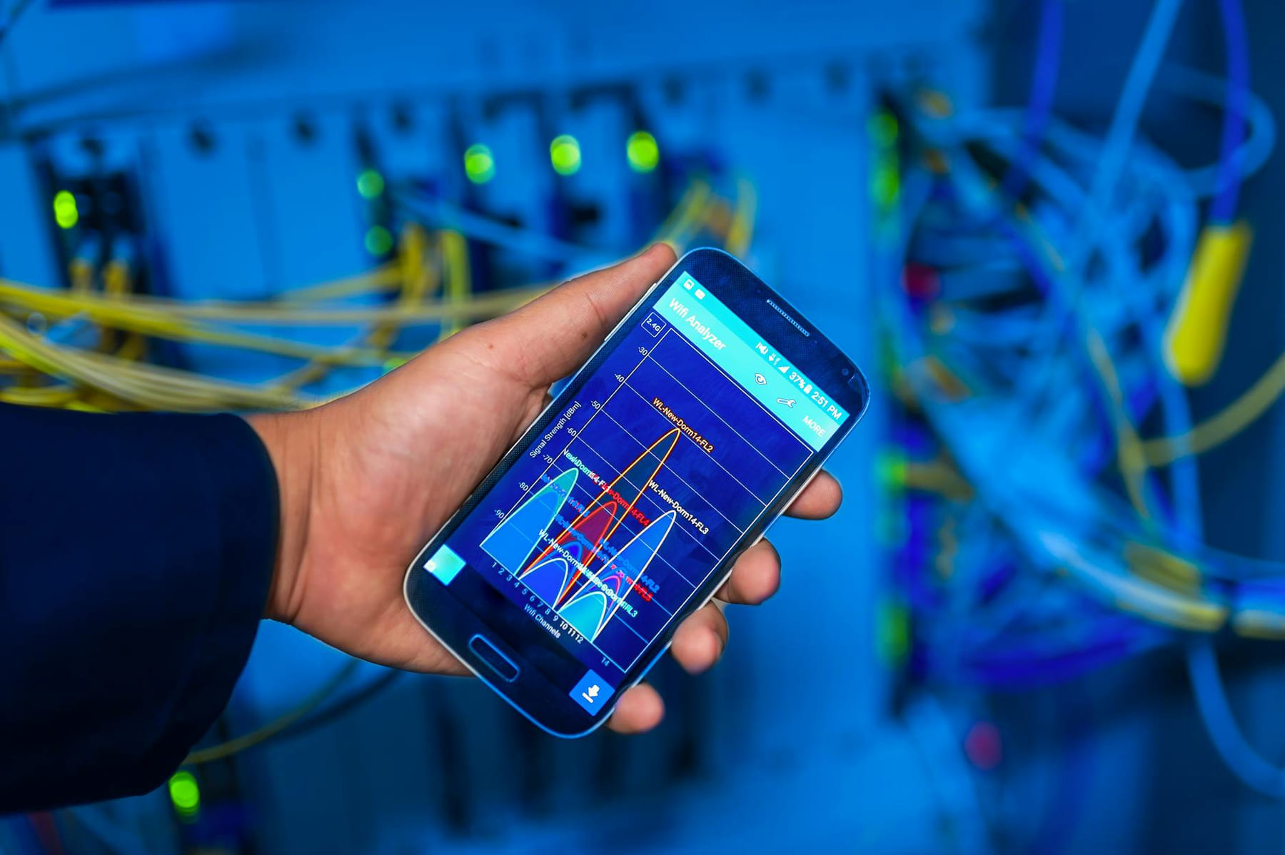 Hand holding smartphone displaying network analysis in high-tech server environment. on The Tech Shelf