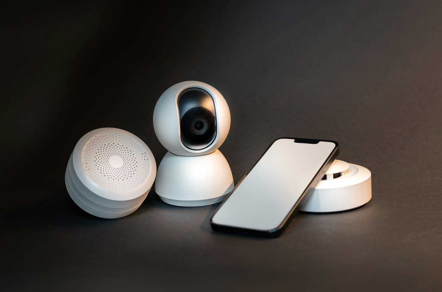 A sleek smartphone with modern smart home devices on a minimalist gray background. on The Tech Shelf