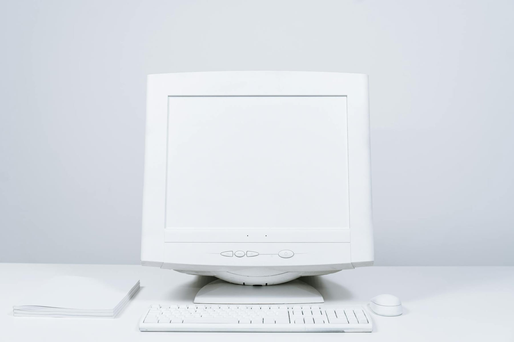 A minimalist white computer setup including monitor, keyboard, and mouse on desktop. on The Tech Shelf